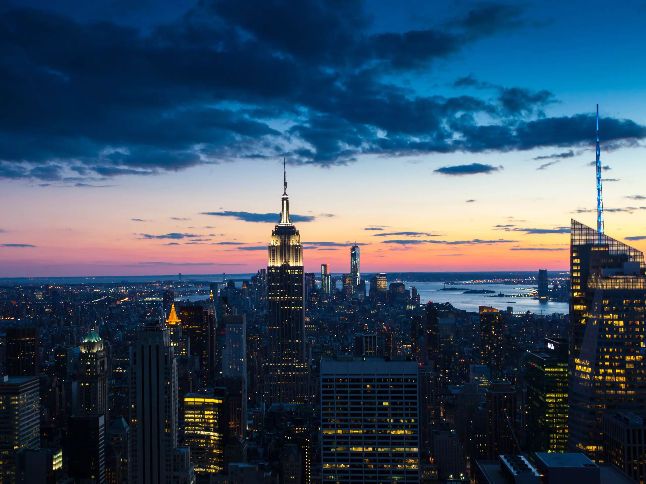 New York City Skyline at night with the river in the background.