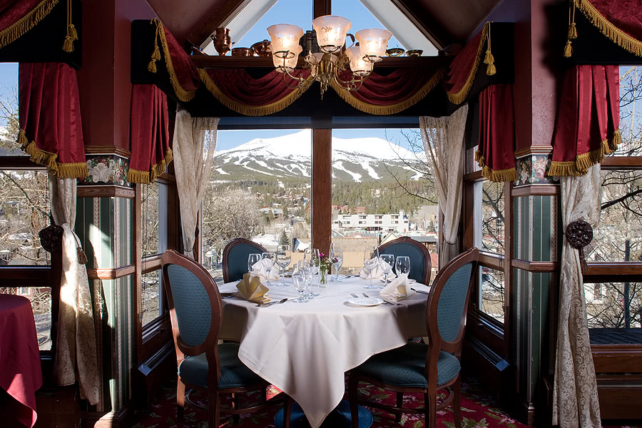 Hearthstone Restaurant interior table in front of a window with snowcapped mountains in the background.