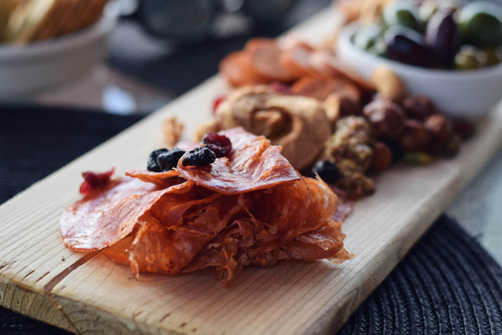 Charcuterie board with meats, nuts, and olives