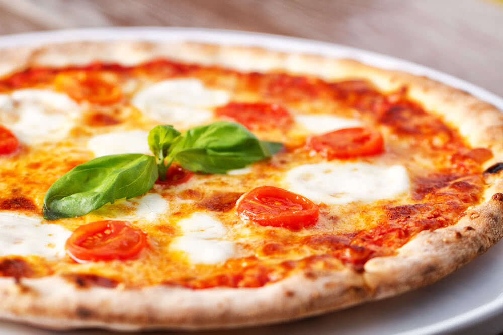 Margherita pizza on a board.