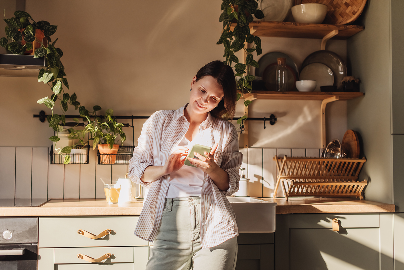 Woman looking at her phone in the kitchen