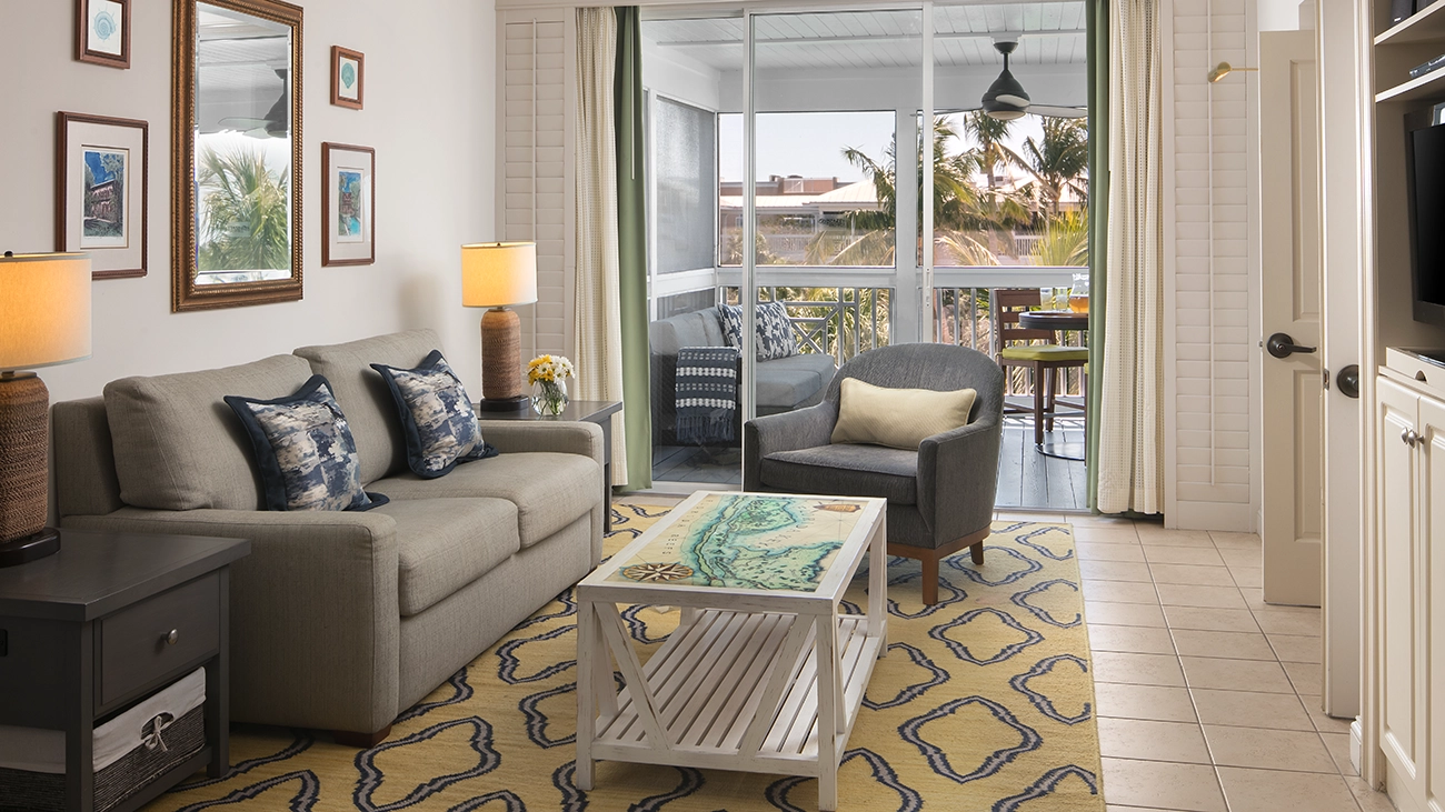 Couches and chairs sit in the living area and attached patio of a villa