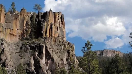 A rocky cliff with trees at Santa Fe National Forest