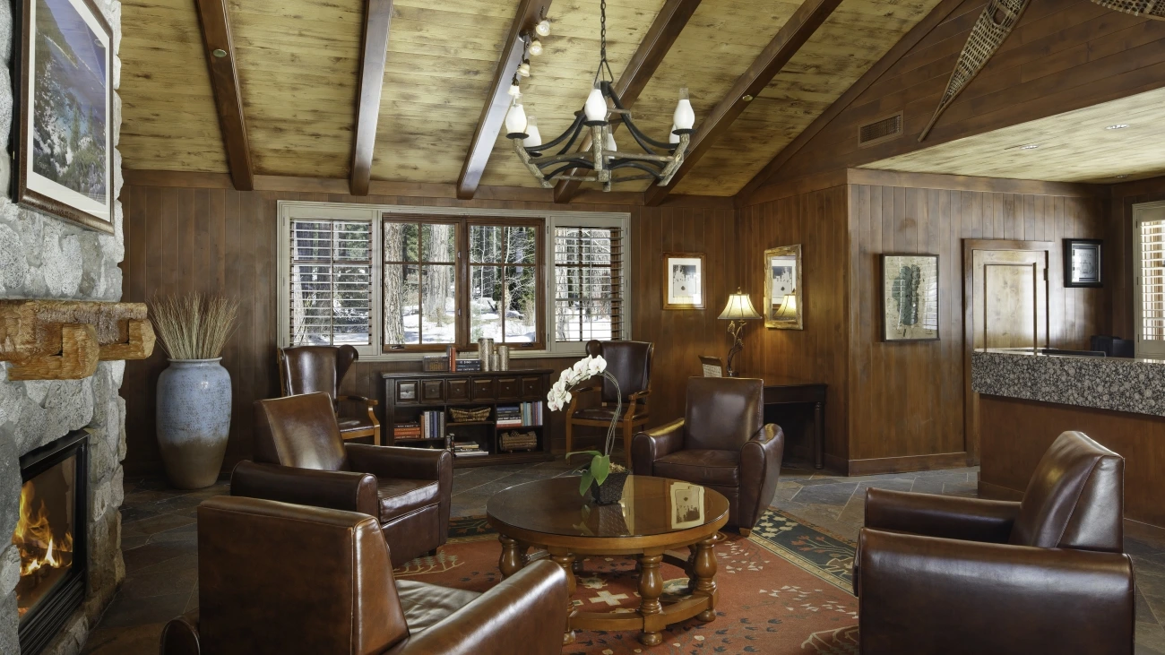 A rustic living room with a vaulted ceiling and fireplace