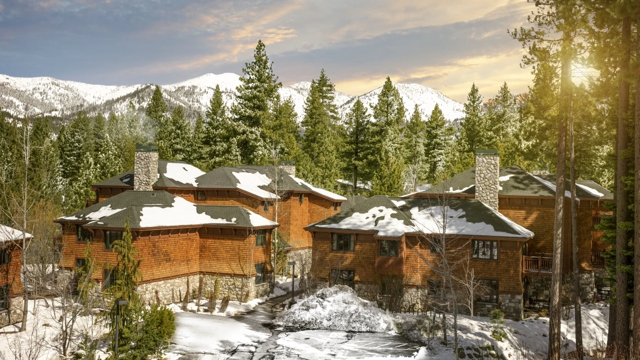 A rustic snow-capped resort, nestled among evergreens and mountains
