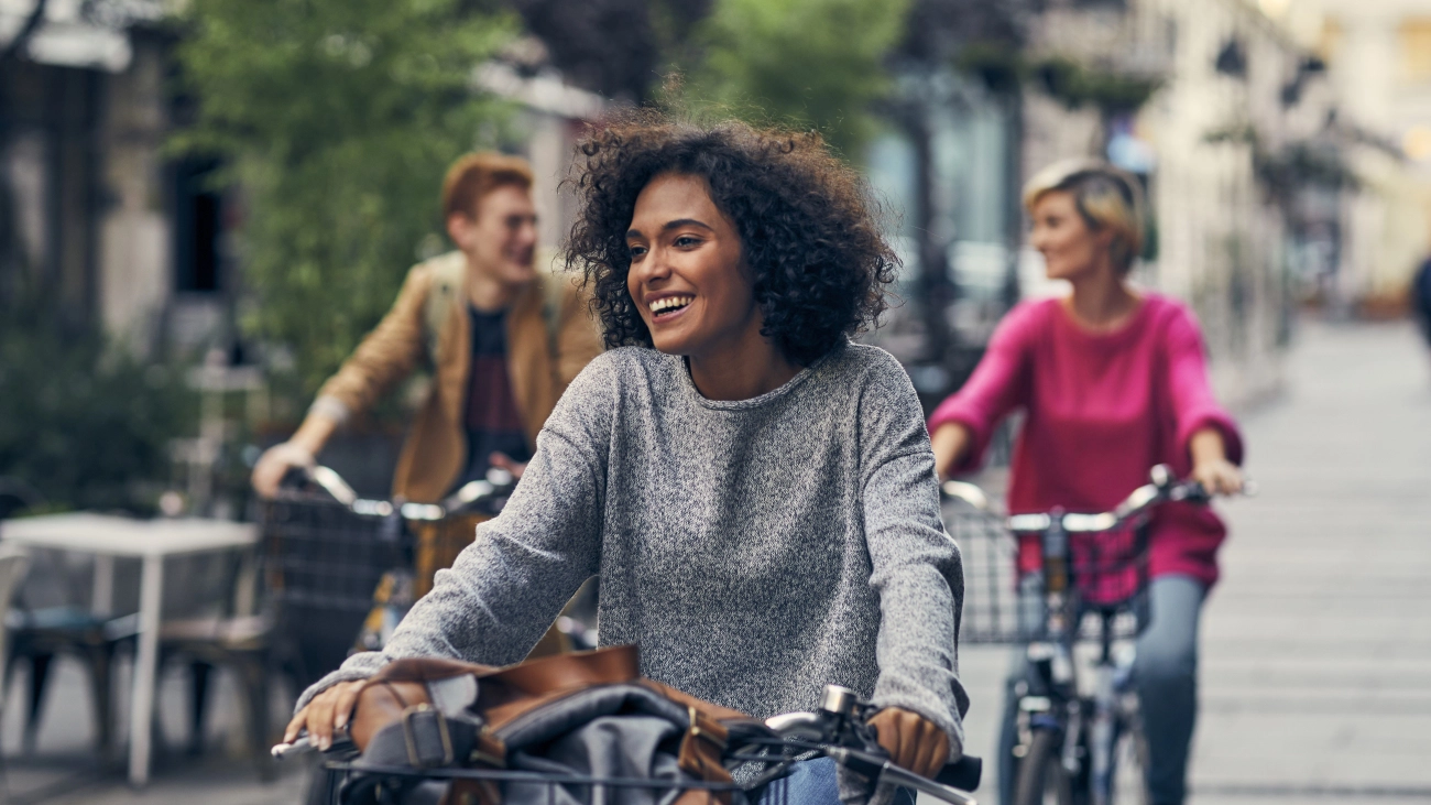 Three people riding bicycles together on a quaint street