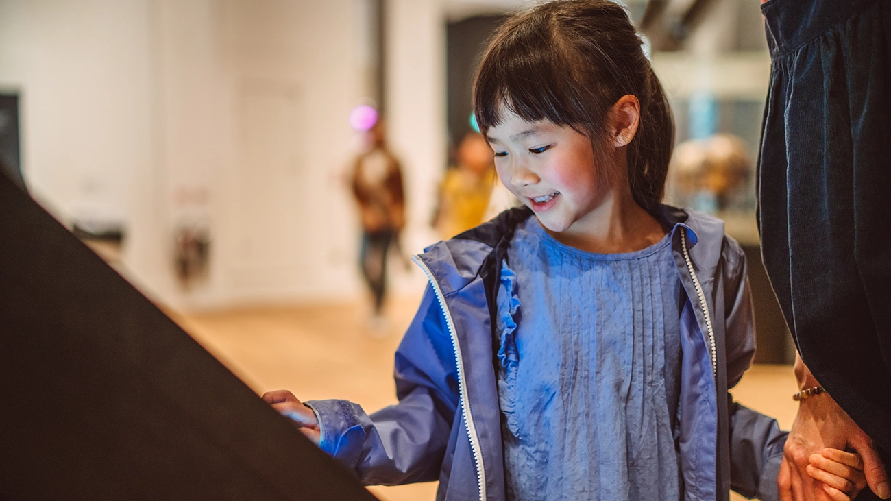 Young girl enjoying an exhibit at a museum