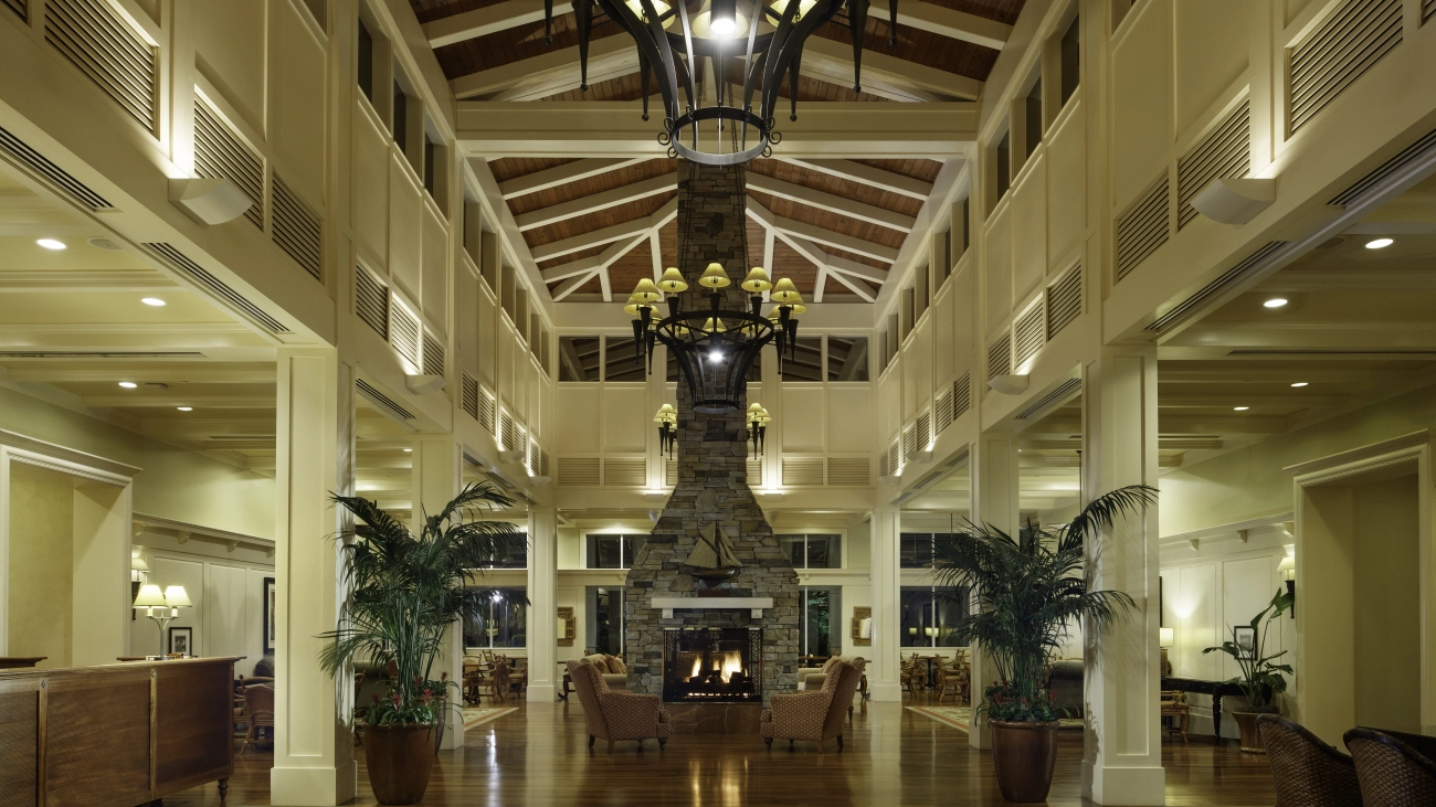 High-ceilinged lobby with chandeliers and working fireplace