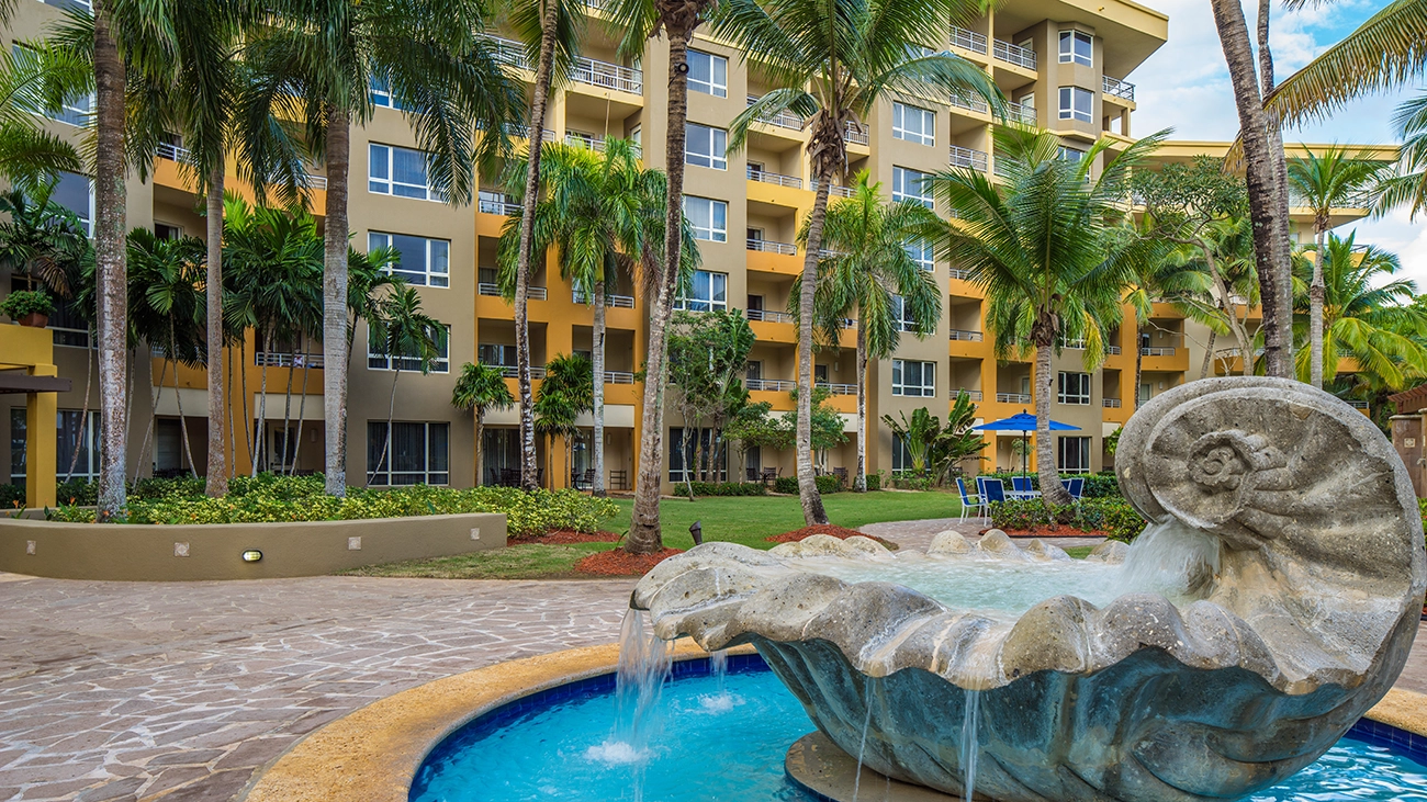 A trickling fountain decorates a walkway and lawn