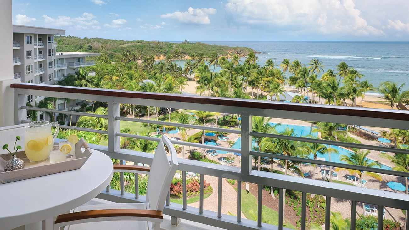 A villa patio overlooks the pool deck and nearby ocean beach