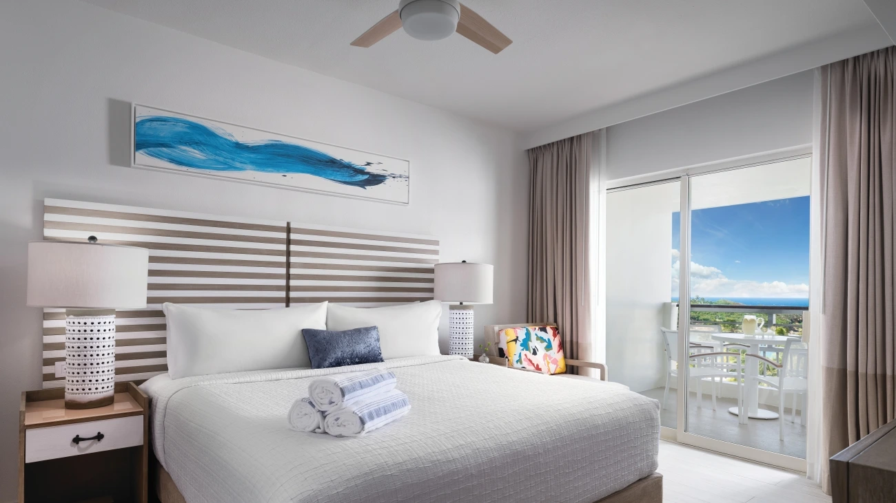 White bedroom with table and chairs on a balcony