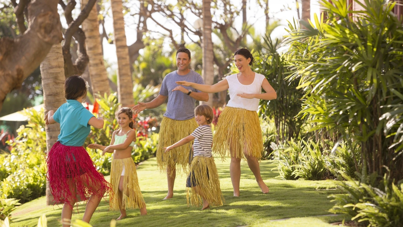 Family enjoying outdoor hula lessons as they visit Hawaii