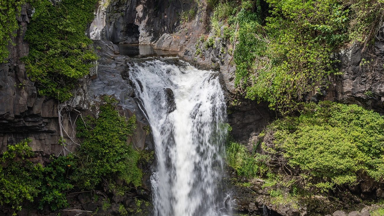 Seven Sacred Pools waterfall with lush foliage