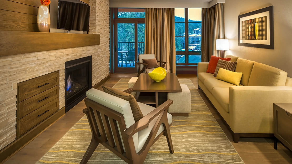 The living area of a villa features a flat-screen TV and fireplace