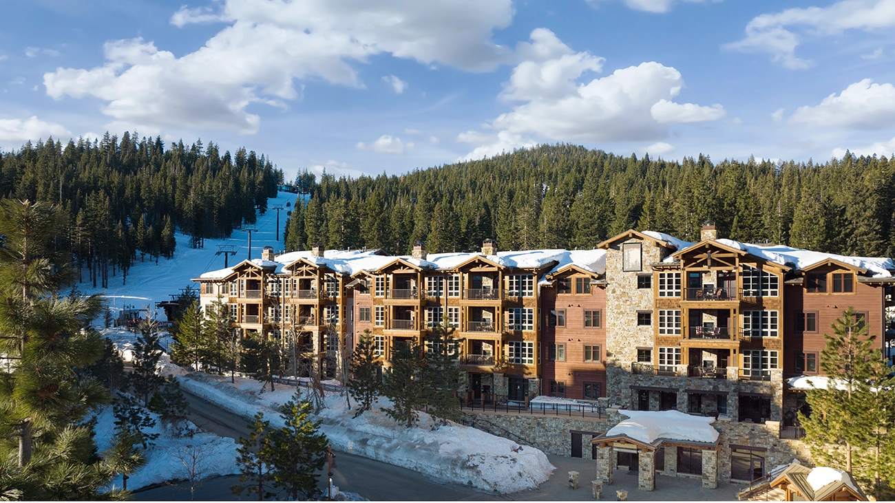 Sprawling ski resort with a ski slope, gondola, and evergreens in the background