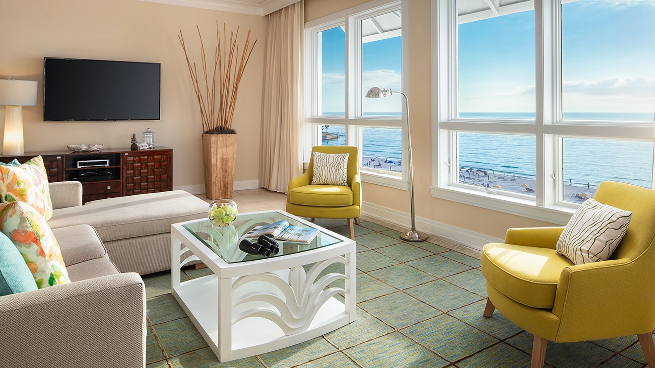 Tropical decorations adorn a villa living area while the beach can be seen out the window