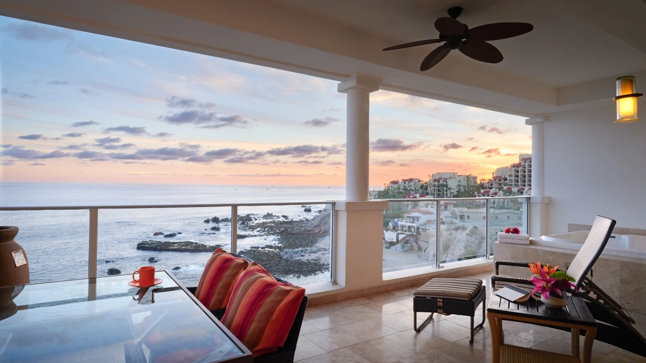 Balcony with whirlpool spa, table, and chairs with a view of the ocean and cliffs