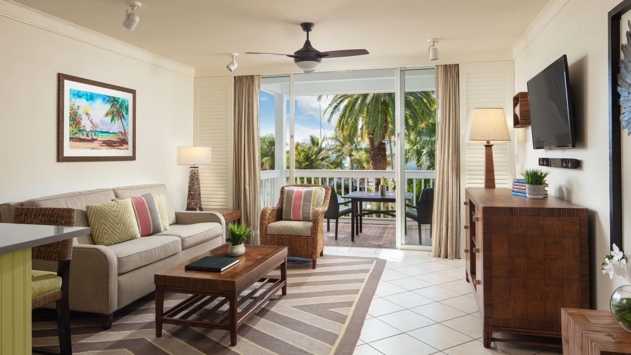 Interior view of a villa living room with a view of palm trees outside