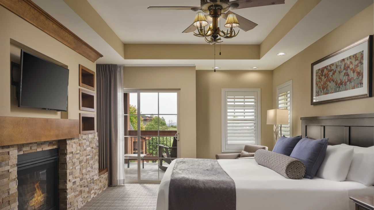 Bedroom with a fireplace and balcony