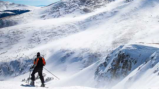 Person skiing along a snowy hill