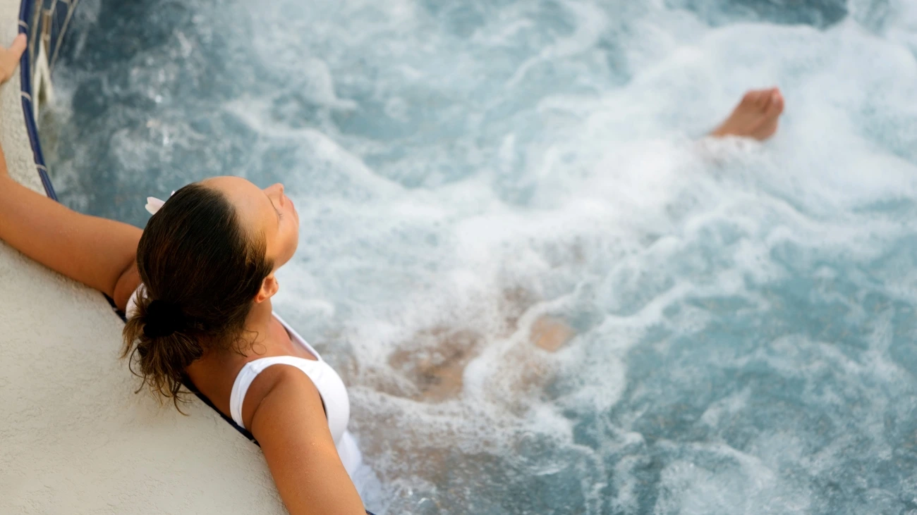 Woman relaxing as she sits in a bubbling hot tub